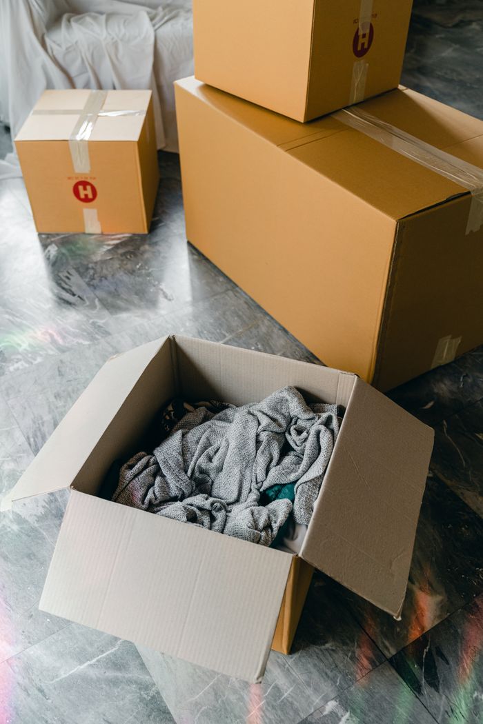 creative-01 From above of cardboard boxes with packed items placed on floor in new apartment