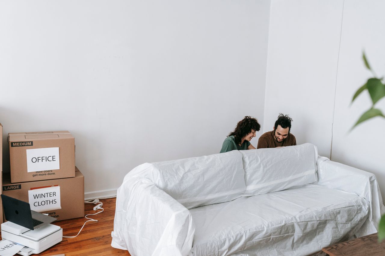mobile-02 A couple enjoys moving into a new home, surrounded by boxes and minimalist decor.